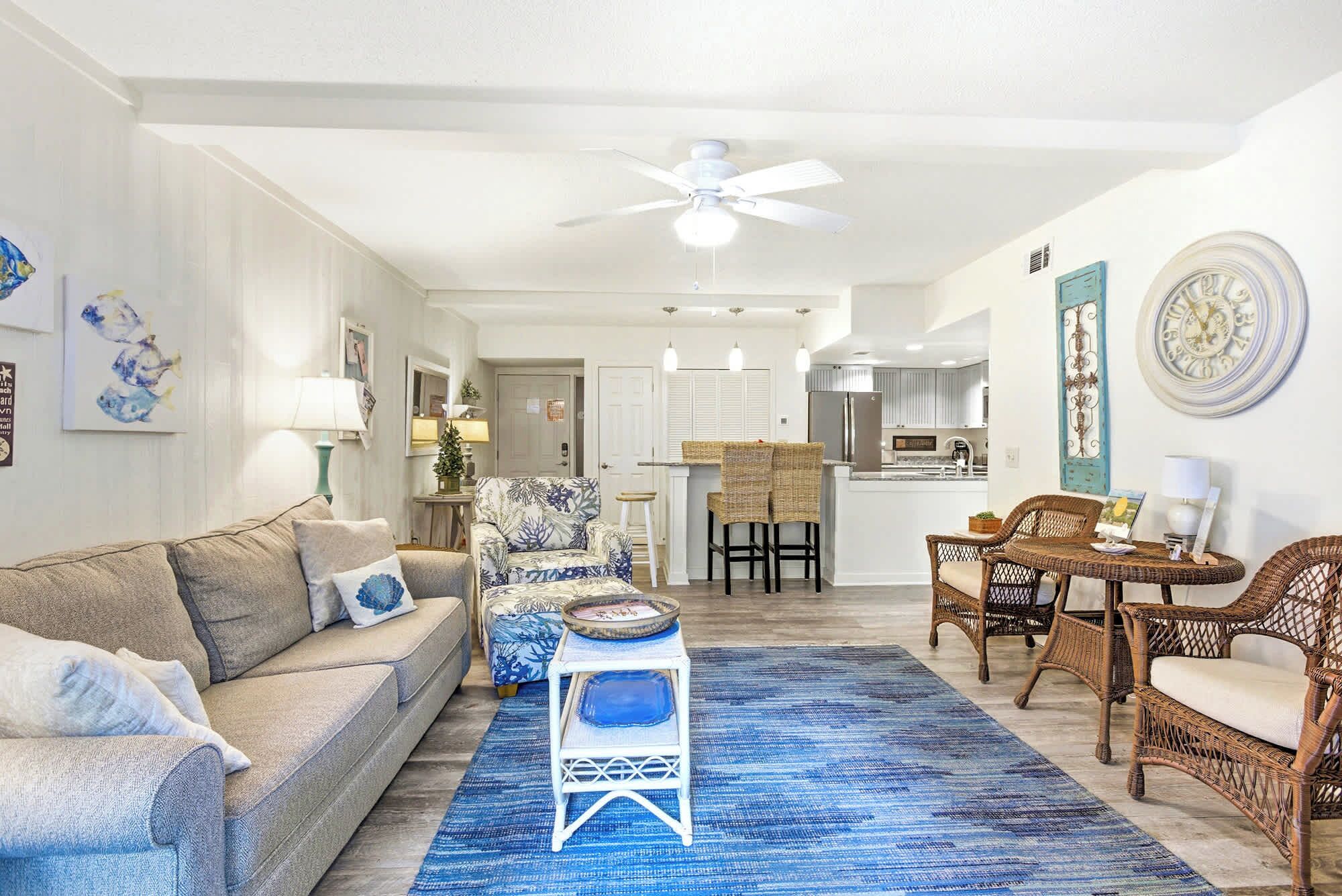 A living room with a sofa, chairs, a coffee table, and a dining area with a table and chairs.