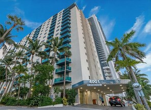 A high-rise hotel with a prominent entrance, numbered 4001, and surrounded by palm trees. - Two Bedroom Resort Suite with Pool and Gym (Hollywood)