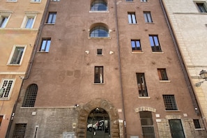 A multi-story building with a central arched entrance and multiple windows.