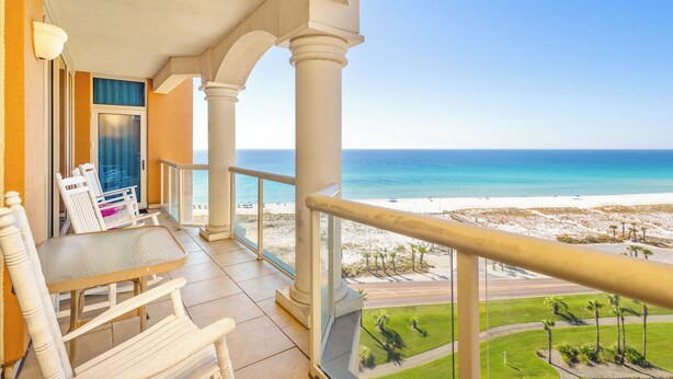 Ein Balkon mit Blick auf Strand und Meer.