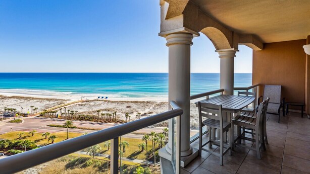 Un balcon avec vue sur la plage et l’océan.
