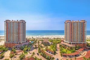 A high-rise hotel with a pool area, beach view, and multiple parking levels.