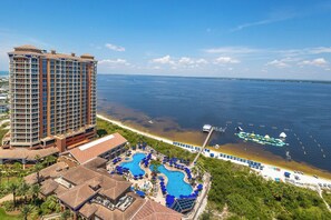 A high-rise hotel with a pool area and beach access.