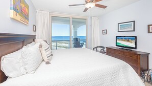 A hotel room with a large bed, a ceiling fan, a television, and a view of the beach. - Stunning Gulf Front Views*Tower 3-0709 (Pensacola Beach)