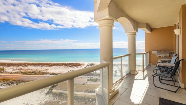 Ein Balkon mit Blick auf Strand und Meer.