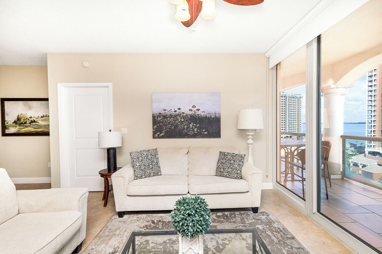 A living room with a sofa, a coffee table, and a painting on the wall.