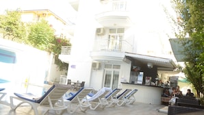 A building with a pool area, lounge chairs, and a bar. - Honor A Pansiyon Side (Manavgat)