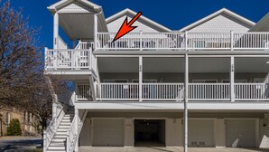 A two-story building with a balcony on the upper floor, a staircase leading to the entrance, and two garage doors. - 1 Block to Beach and Boardwalk "Between the Piers" (Wildwood)