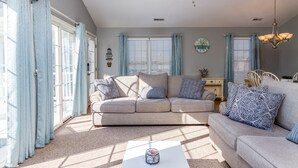 A living room with a beige sofa, a white coffee table, and a ceiling fan. - 1 Block to Beach and Boardwalk "Between the Piers" (Wildwood)