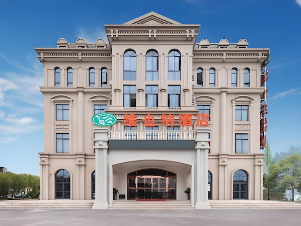 Um edifício grande em estilo clássico, com uma entrada imponente e várias janelas.