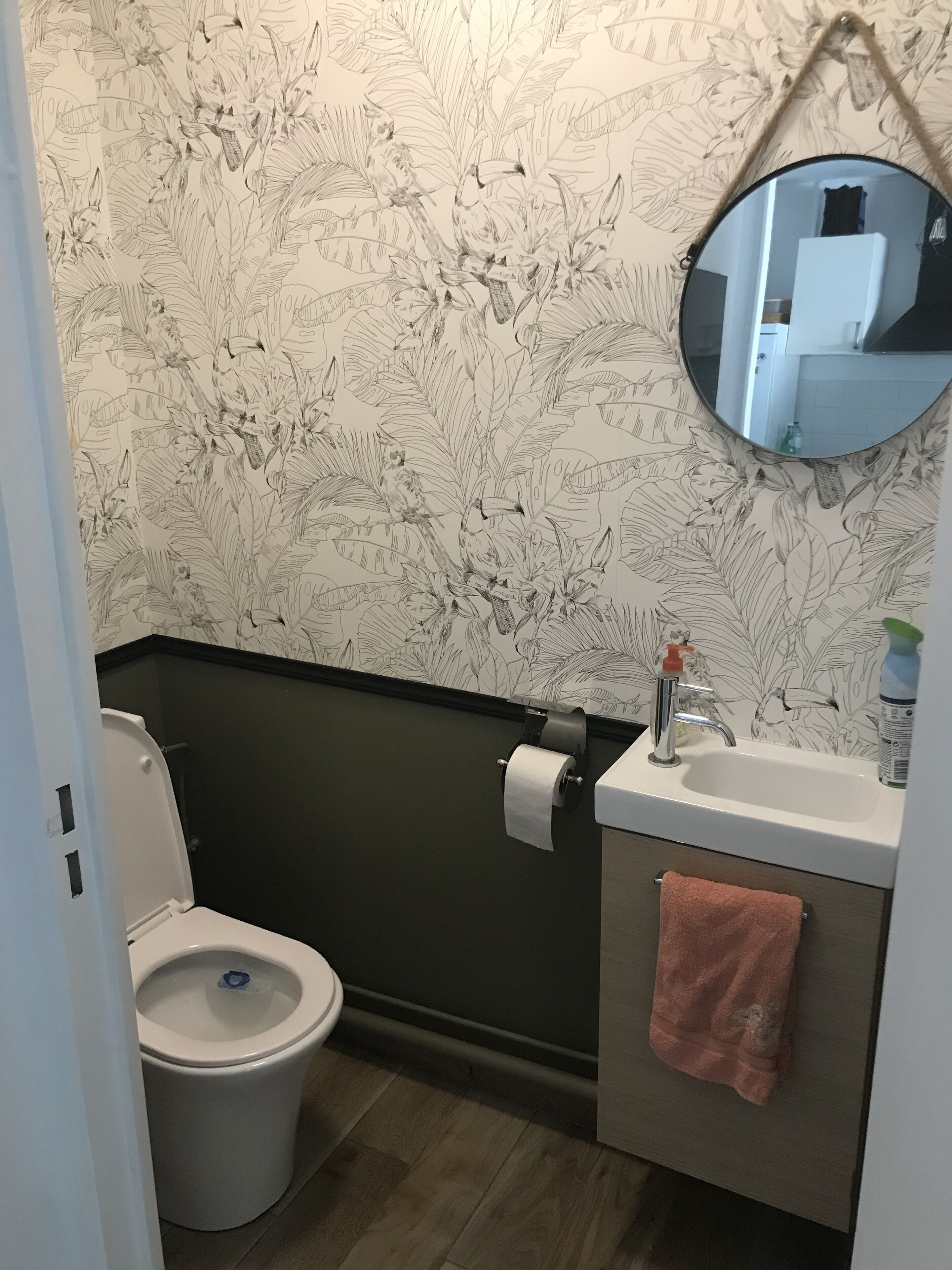 Ein Badezimmer mit Toilette, Waschbecken und Spiegel.
