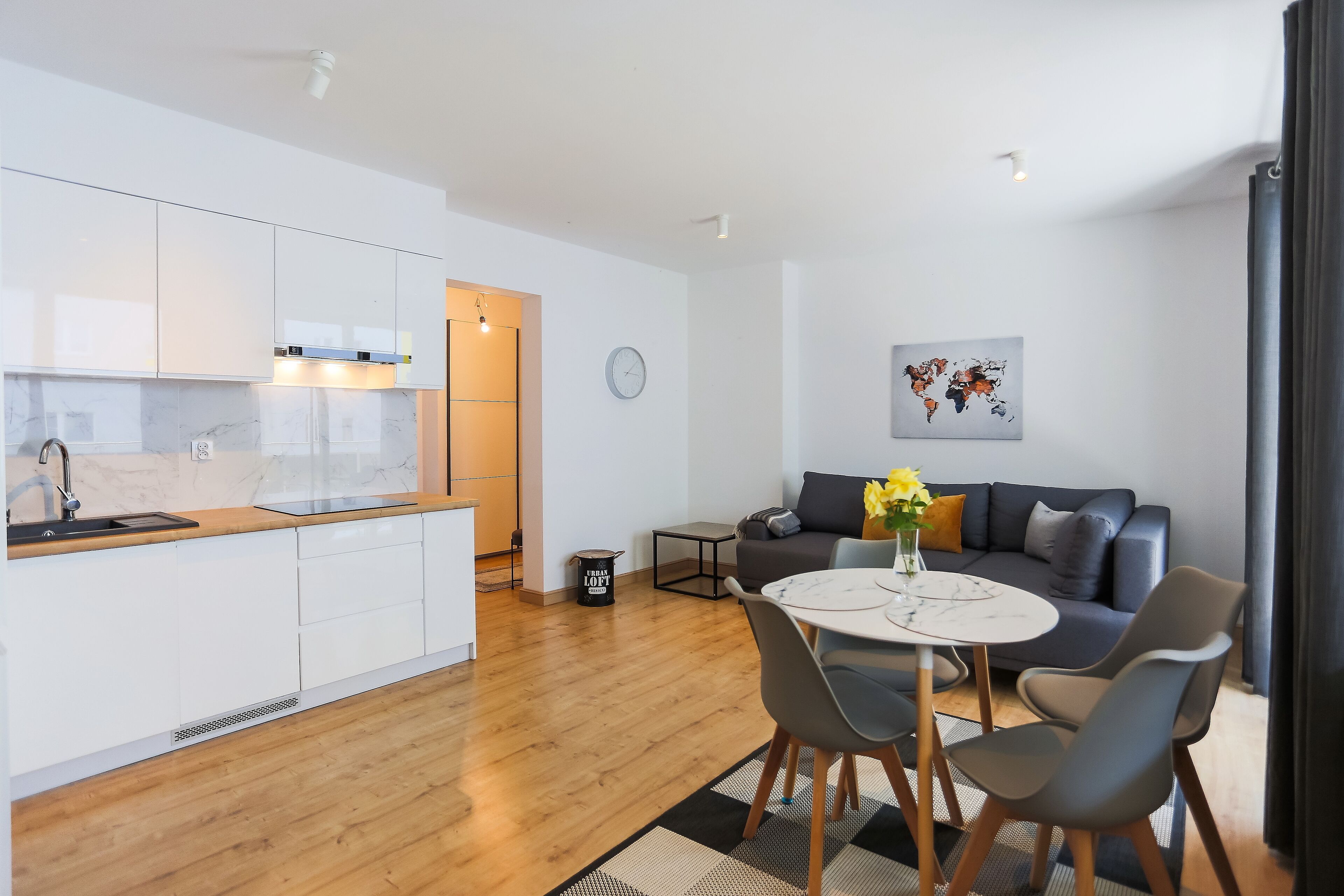 A modern apartment with a kitchen, dining area, and living room.