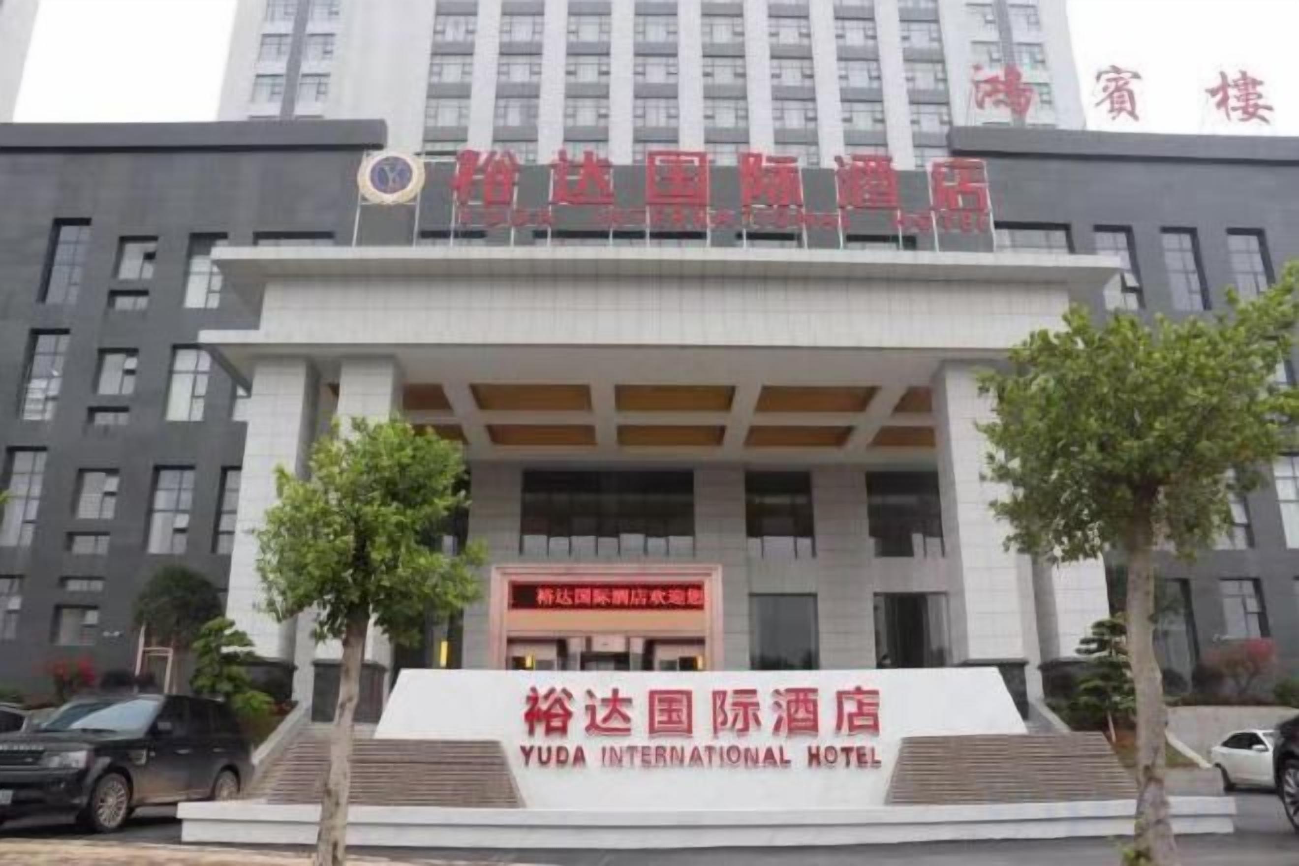 A hotel with a prominent entrance, a signboard, and a modern building facade.
