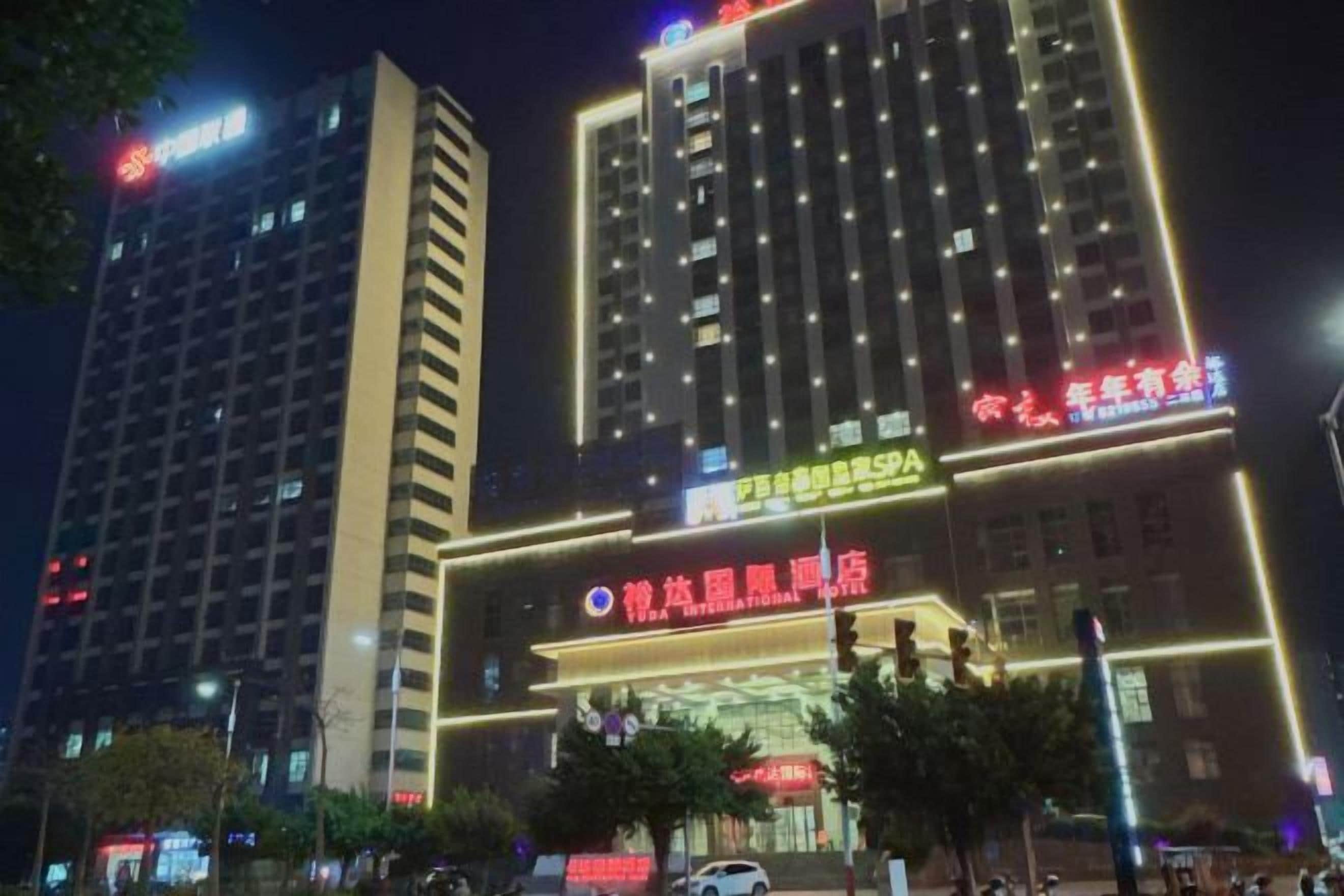 A multi-story building with illuminated signage, likely a hotel or commercial complex, with a prominent entrance and visible signage.