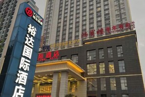 A hotel entrance with a prominent sign for the Yuda International Hotel. - Yuda International Hotel (Wuxuan)
