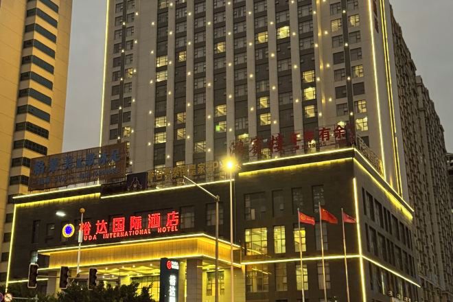A hotel with a prominent sign, multiple floors, and illuminated windows.