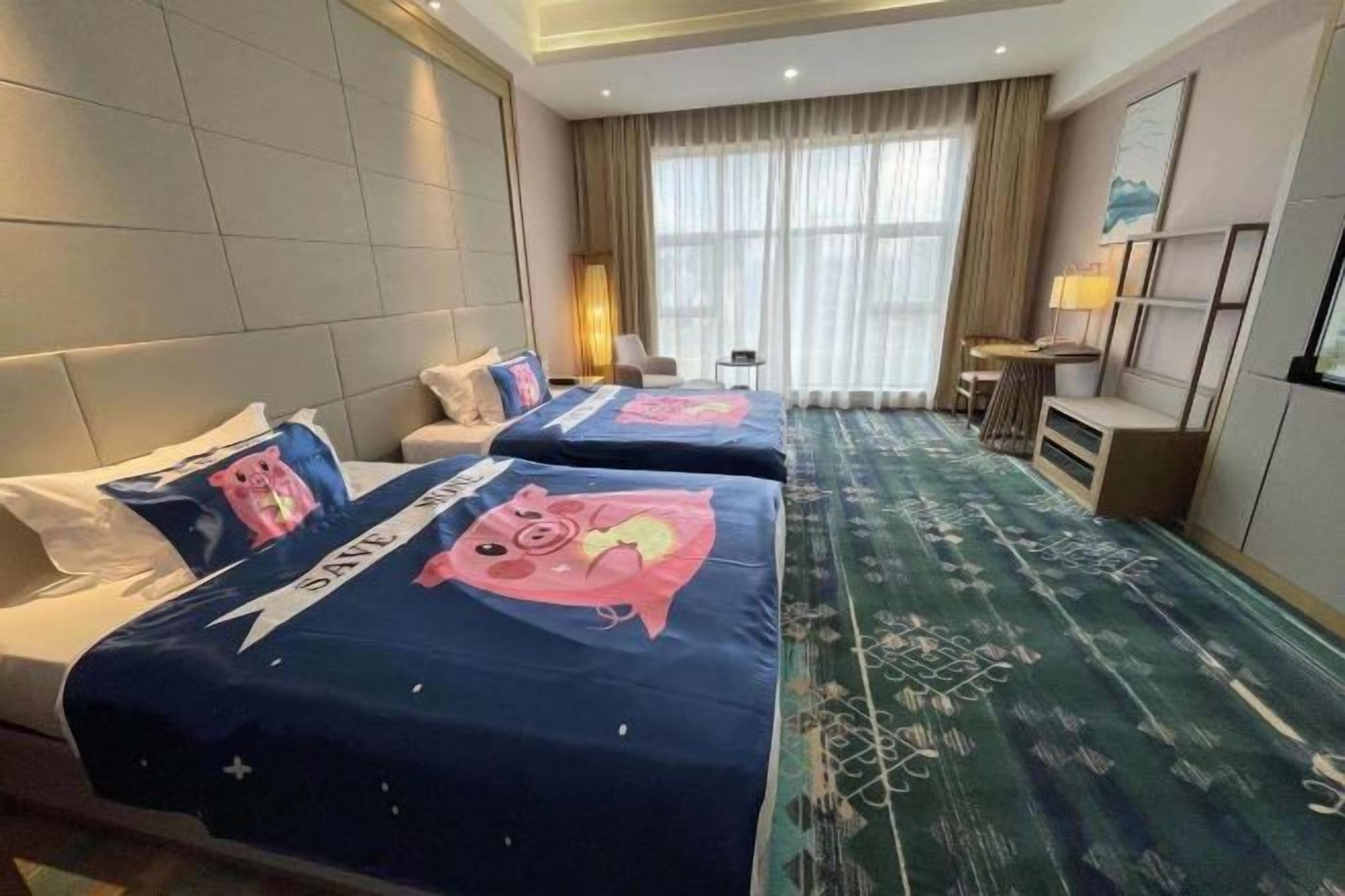 Une chambre d’hôtel avec deux lits, un canapé, un bureau et une vue sur l’extérieur.