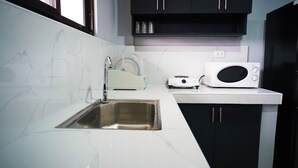 A kitchen with a sink, a microwave, and a toaster. - Cozy and homelike accommodations (Olongapo City)