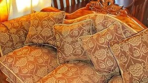 Een gezellige zithoek met een zette, een decoratieve vaas en een houten eettafel.