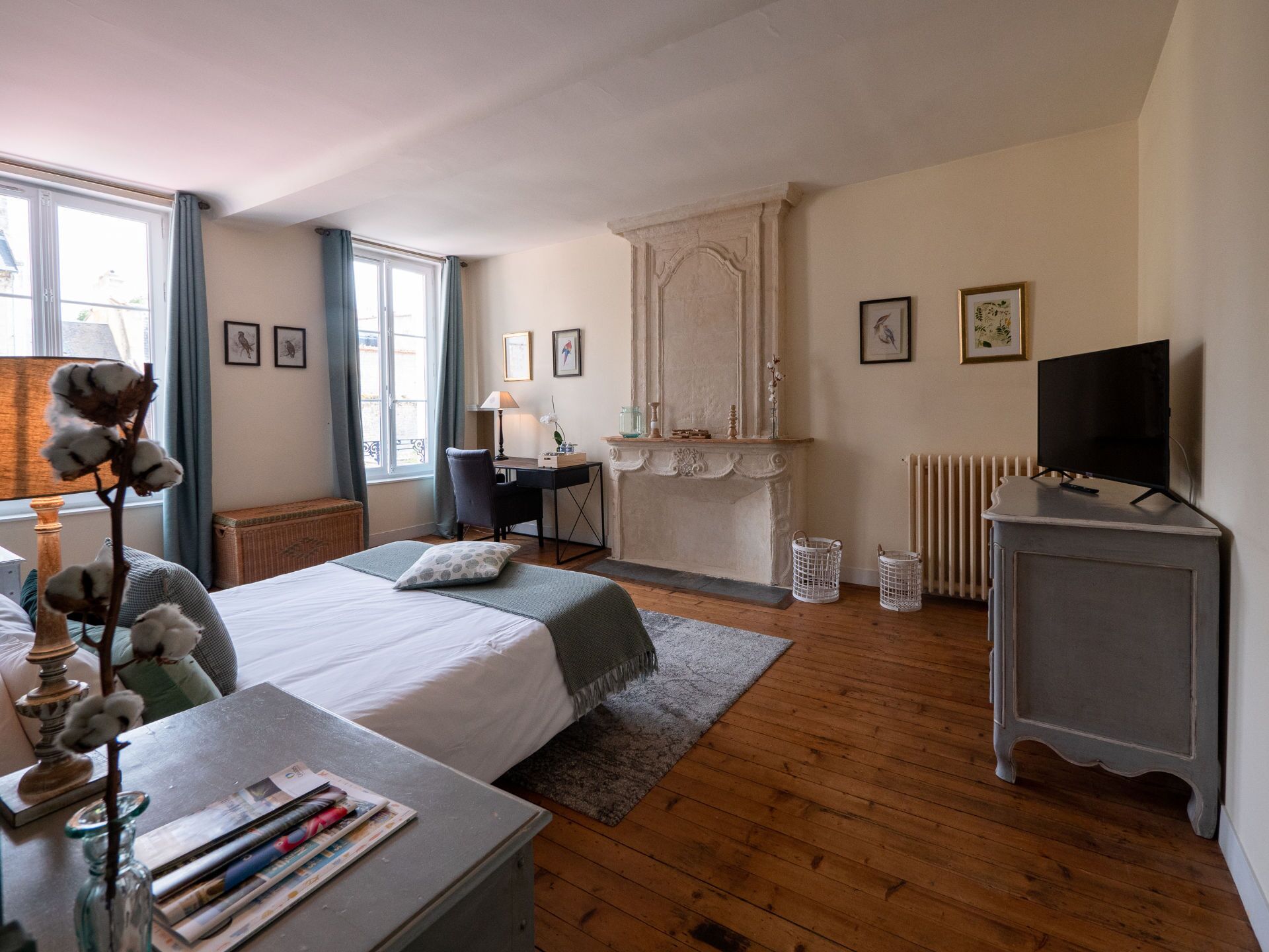 A bedroom with a bed, desk, chair, and a television.