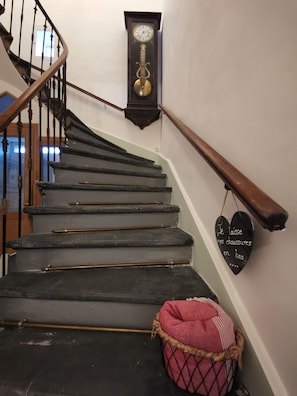 A staircase with a wooden handrail, a wall-mounted clock, and a heart-shaped sign with text. - House sleeps 16 near the Camargue Sea in the Cévennes—quiet location (VERGEZE)