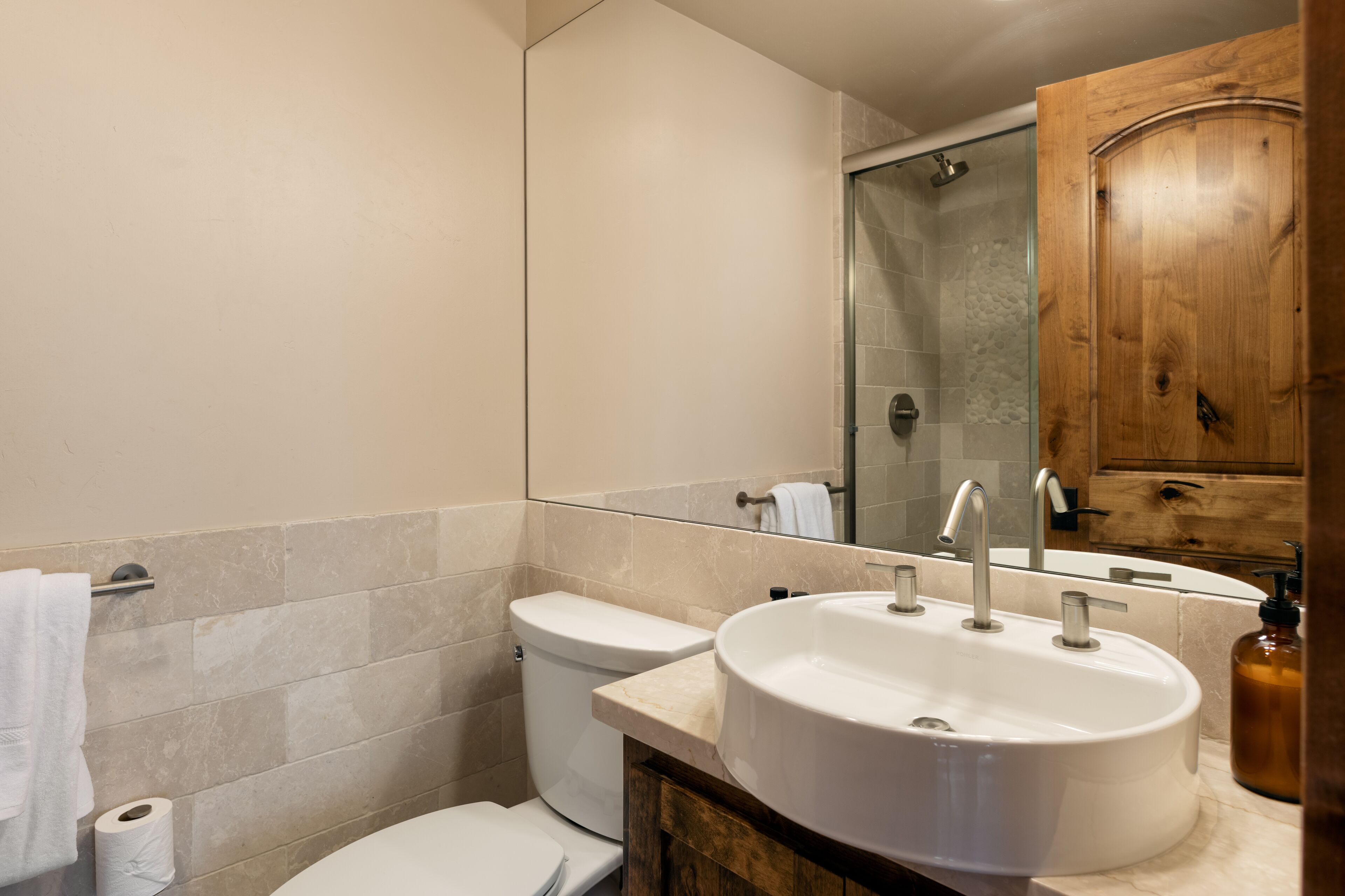 A bathroom with a toilet, sink, and shower.