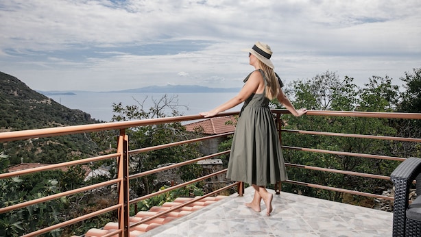 A woman standing on a balcony with a railing, overlooking a mountainous landscape and a body of water. - Vila Leon - Old Qeparo (Upper Qeparo)