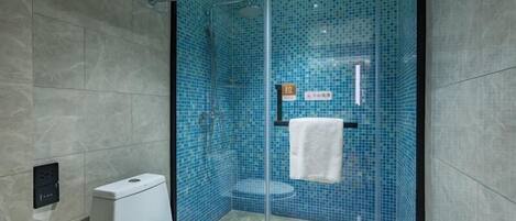 A modern bathroom with a glass-enclosed shower, a toilet, and a towel rack.