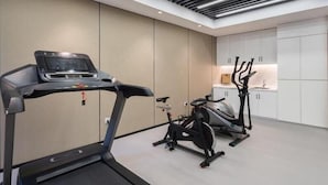 A modern home gym with a treadmill, stationary bike, and elliptical machine. - Greentree Eastern Xuzhou High Speed Railway Station Square Yindi Automobile Market Hotel (Xuzhou)