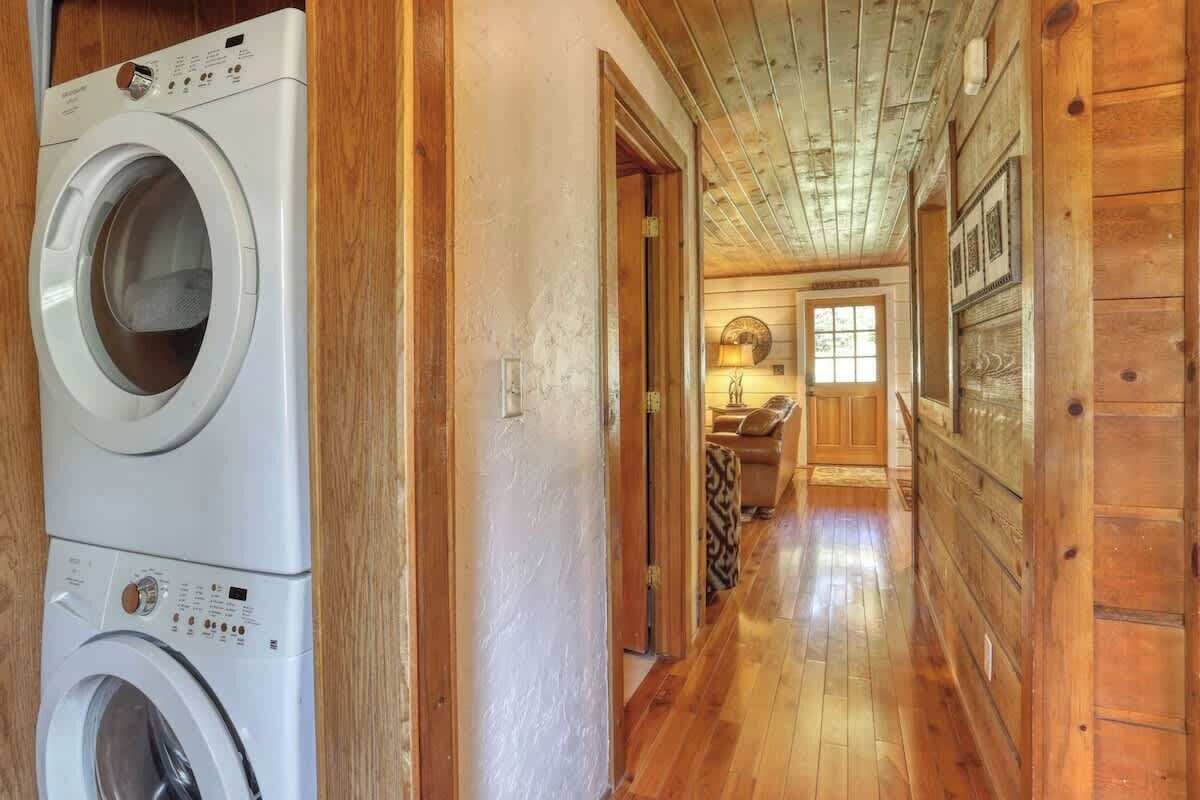 Un cuarto de lavandería con lavadoras apiladas y detalles de madera.