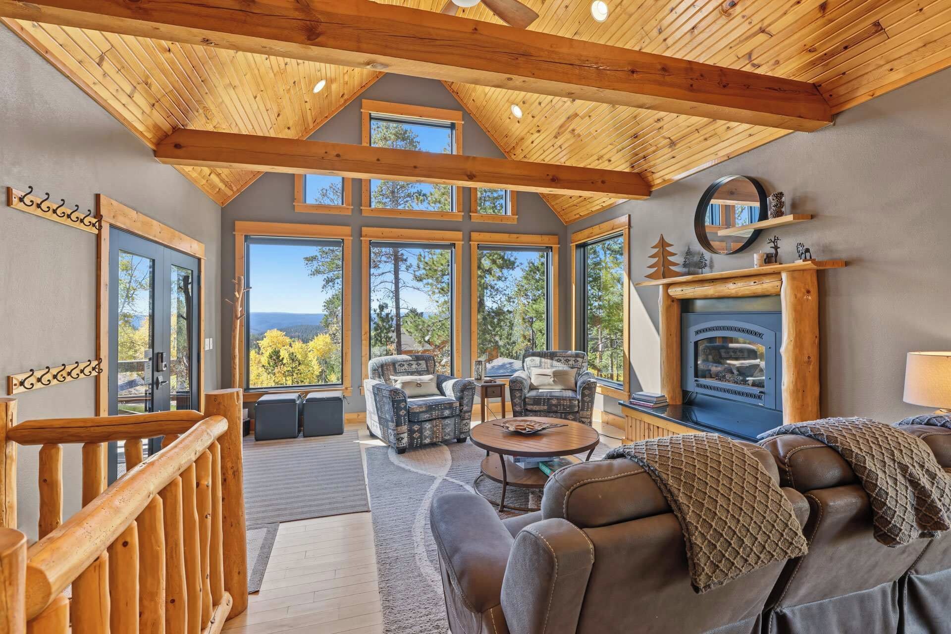 A spacious living area with a fireplace, large windows, and a view of the outdoors.