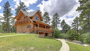 A large wooden lodge with a balcony and a covered porch, surrounded by trees. - Wannabee Moose Lodge (Sturgis)