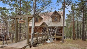 Une cabane rustique appelée « Septième Ciel », dotée d’une terrasse en bois et d’une enseigne.