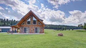 Una cabana de fusta de planta baixa, amb fonaments de pedra i un teulat a dues aigües destacat.