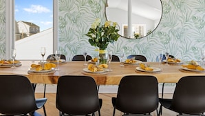 A dining room with a wooden table set for six, black chairs, and a large mirror on the wall. - 5BR w/ Pool, Hot Tub, Cabana, Elevator & Game Rm (Brigantine)