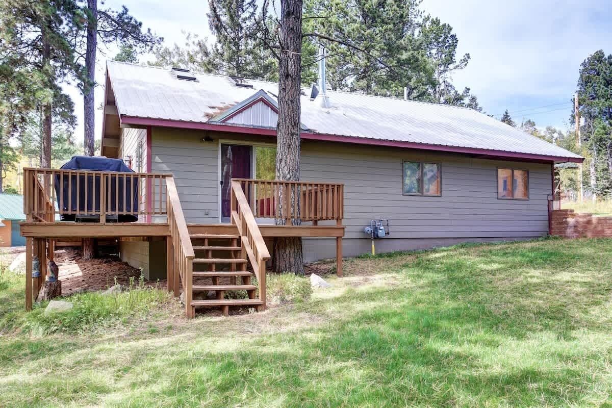 A single-story house with a wooden deck and a small porch.