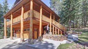 A two-story log cabin with a balcony, stone pillars, and a stone foundation. - Eagle`s Lair (Lead)