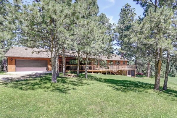 A two-story log cabin with a garage, surrounded by pine trees. - Chase`s cabin by the creek (Lead)