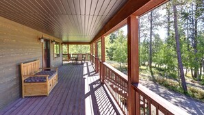 A wooden deck with a bench and table, surrounded by a forest. - Triple R Retreat – Hot Tub, Loft & Black Hills Views (Lead)
