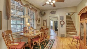 A dining area with a wooden table and chairs, a ceiling fan, and a staircase leading to another level. - Mountain Oasis - private hot tub and game room. (Lead)