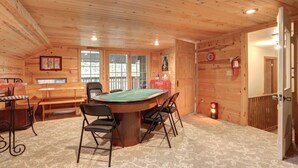 A cozy room with a pool table, wooden walls, and a bench. - Mountain Oasis - private hot tub and game room. (Lead)