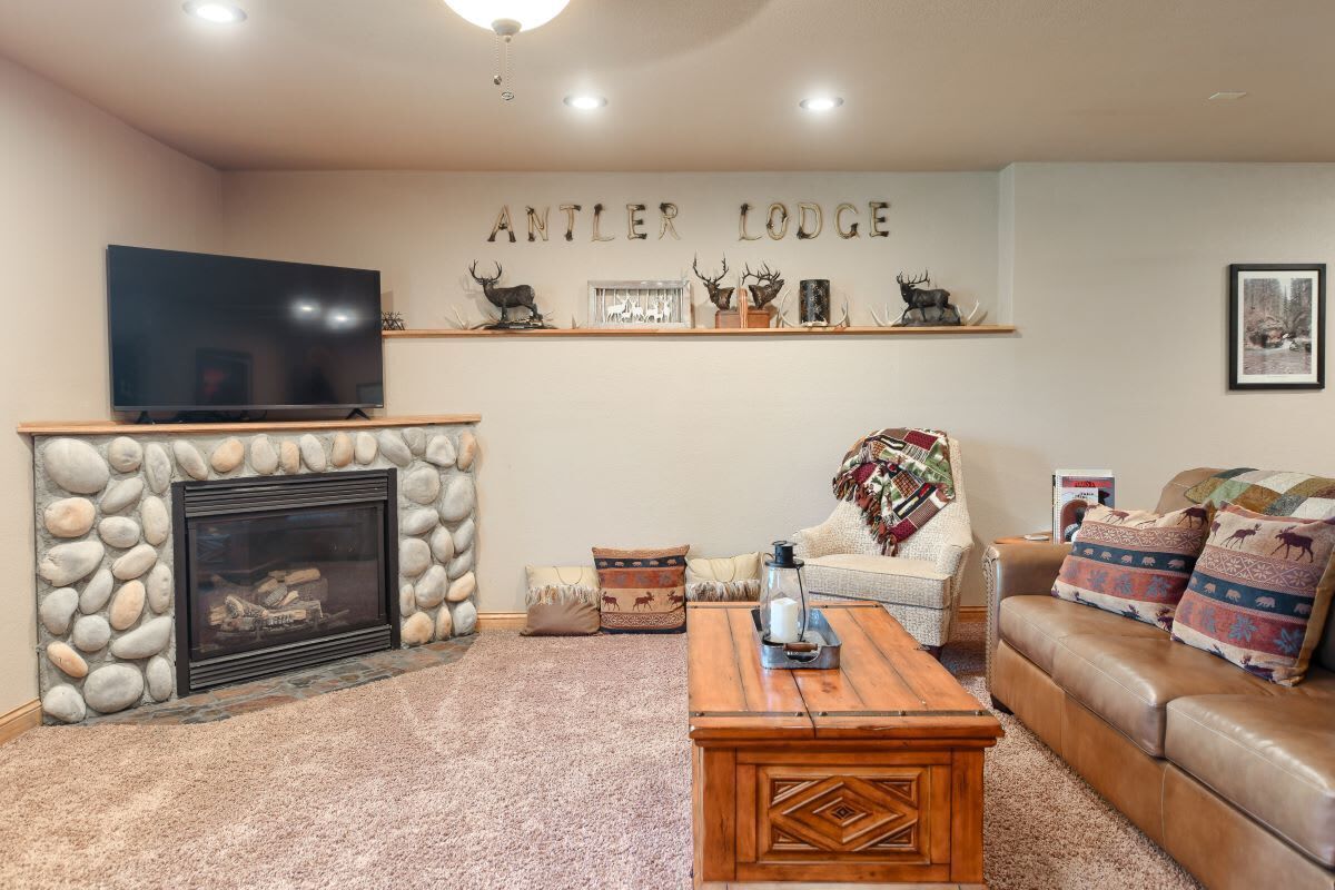 A living room with a stone fireplace, a television, a sofa, and a coffee table.