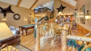 A spacious room with a pool table, wooden dining table, and a cozy seating area. - Rocky Ridge Lodge – A Black Hills Escape for Family & Friends! (Lead)