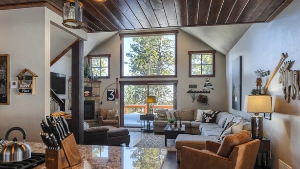 A spacious living area with a large window, a kitchen with granite countertops, and a cozy seating area with a fireplace.