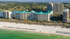 Um hotel à beira-mar com vários edifícios altos, uma praia e vista para o oceano.