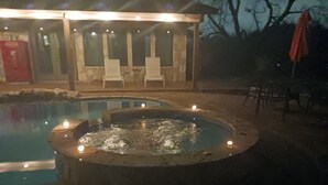 Een zwembadgedeelte met twee whirlpools en een overdekte zithoek.