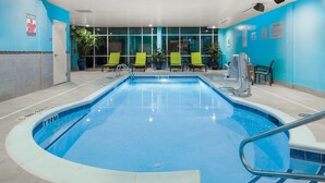 An indoor swimming pool with clear lane markings, a lifeguard station, and several lounge chairs. - SpringHill Suites by Marriott Raleigh Apex (Apex)