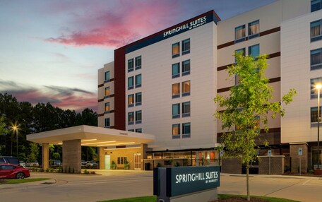 A hotel with a modern design, labeled "Springhill Suites by Marriott," featuring a prominent entrance and a parking area.