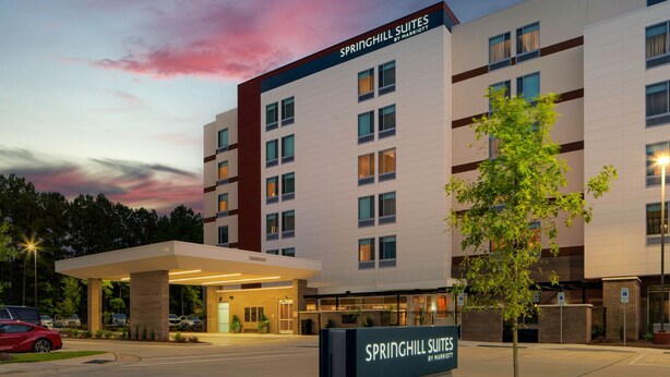A hotel with a modern design, labeled "Springhill Suites by Marriott," featuring a prominent entrance and a parking area. - SpringHill Suites by Marriott Raleigh Apex (Apex)