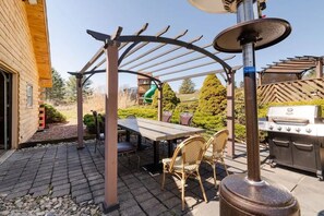 An outdoor patio with a pergola, a grill, and a dining table with chairs. - Private Cabin · Heated Pool, Sauna & Hot Tub · 2 Acres (Tunkhannock)